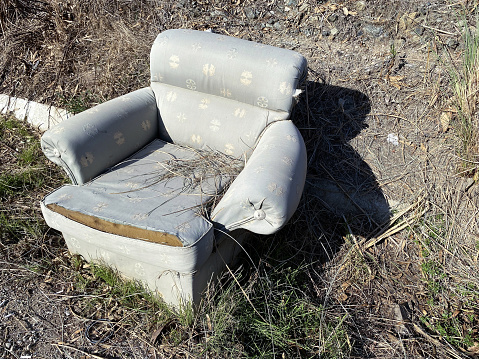 An old berger-type armchair thrown into the street. Taken on mobile device (iPhone 11)