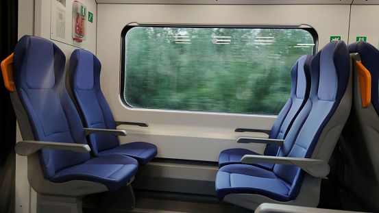 Train window with blurred landscape and empty seats