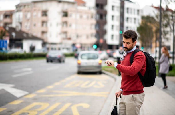 young man waiting for a bus - color image bus discussion expertise imagens e fotografias de stock