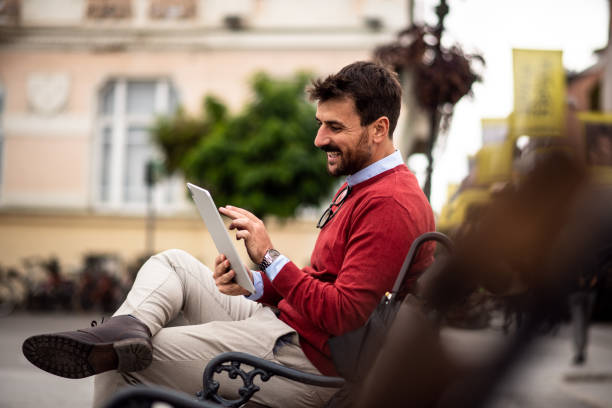 istock Attractive young freelancer working on an iPad in town square 1438487548