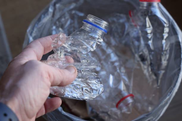 istock Hand placing bottles in recycling bin 1438488196