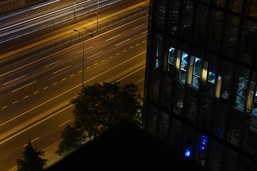 Working overtime in the middle of night in the fifth floor of a skyscraper. lights are on and will continue for many hours