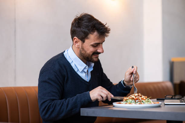 istock Handsome young man in a restaurant eating 1438489385
