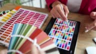 istock A woman in the office looks at color samples from a palette 1438502041