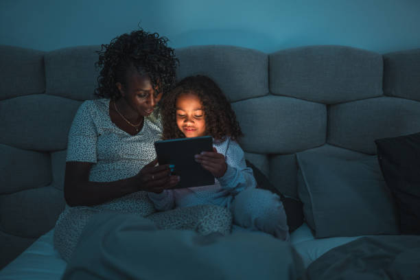 istock Mother And Daughter Reading An E-Book At Night 1438502445