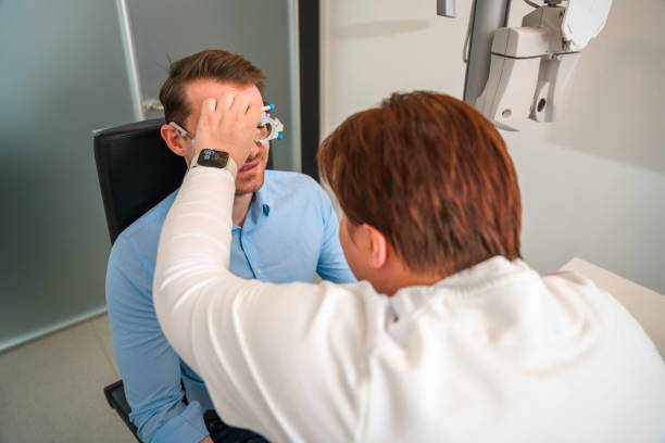 istock Eye Care Professional Putting on Diagnostic Medical Tool on White Man 1438502602