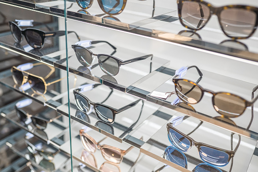 Shot of sunglasses on top of bright showcase. They are modern and stylish.