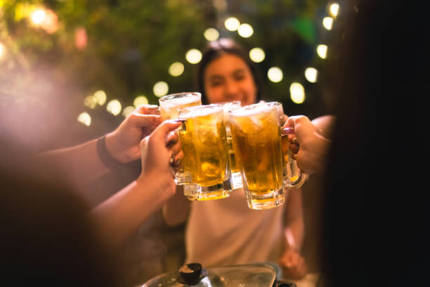 Evening group of friends drinking beer and clinking glasses. stock photo