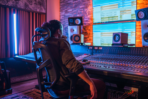 view of sound producing equipment at recording studio with armchair on foreground