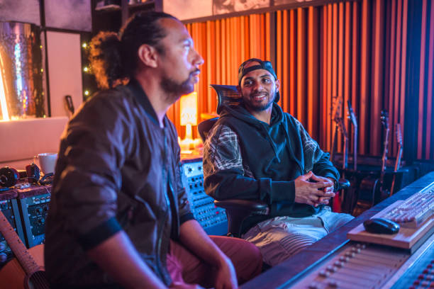 istock Two Male Musicians Operating With Sound Recording Studio Mixer 1438504723