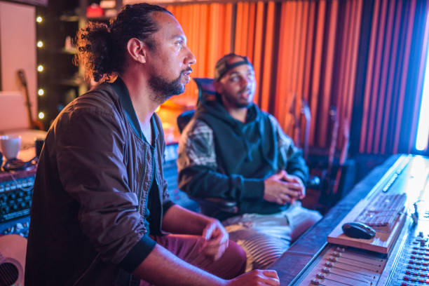 istock Two Male Musicians Operating With Sound Recording Studio Mixer 1438504725