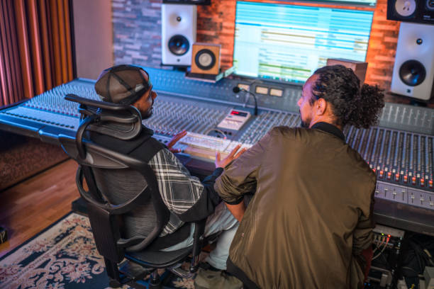 istock Two Male Musicians Operating With Sound Recording Studio Mixer 1438504732