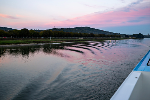 Beautiful sunset on big river and illuminated banks towards the setting sun. Danube, Serbia.