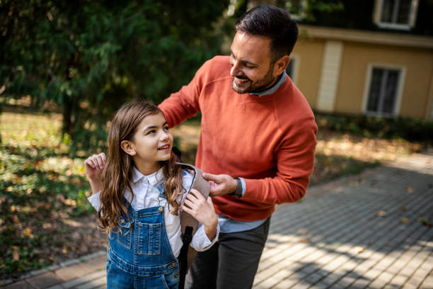 Father take their nine-year-old daughter to school