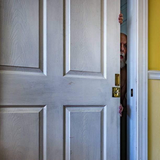 istock Creepy Old Man Peeking Through Cracked Open Doorway 1438527182