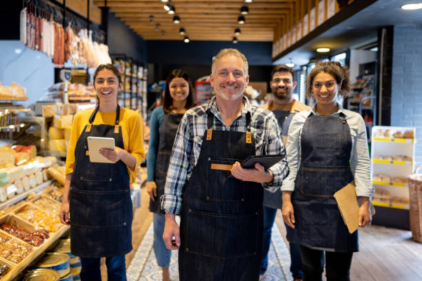 istock Happy group of workers smiling at a supermarket 1438530458