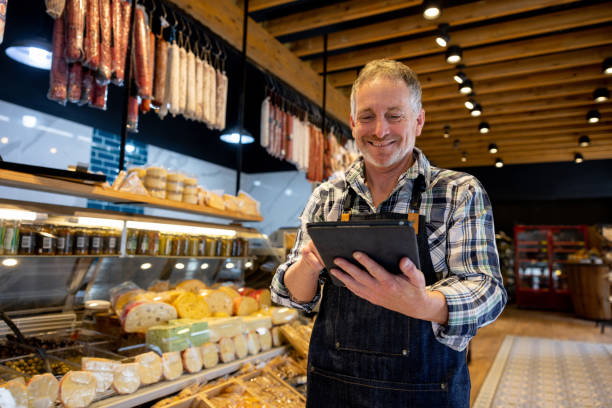 istock Retail clerk working at a supermarket and using a tablet computer 1438530459