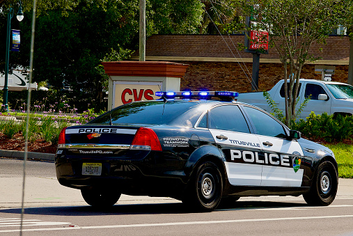 Titusville, Florida, USA - May 30, 2020: A City of Titusville police car pulls up behind another vehicle during a routine traffic stop.
