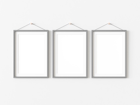 Three rectangular pictures with thin grey border hanging on white wall. Empty template for adding your content. 3D illustration.