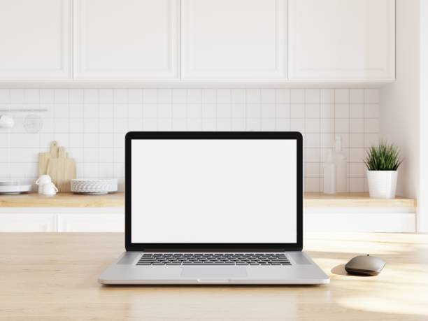 istock Open laptop with white screen for adding your content. Wooden desk in kitchen with counter in background.. 3D illustration. 1438541521