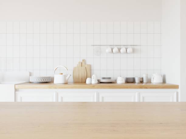 istock Empty desk with wooden surface for displaying your product. Dishes on kitchen counter in background. 3D illustration. 1438541536