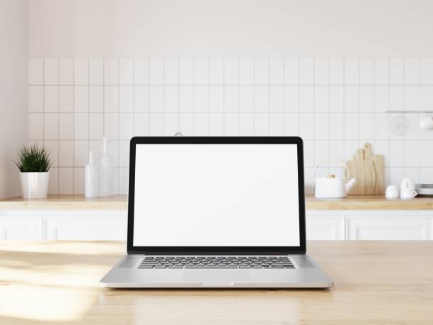 istock Laptop laying on wooden desk in home interior. Blank screen for adding your content. Kitchen background. 3D illustration. 1438541542