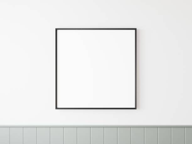 istock Single empty square black lined picture frame hanging on white wall with grey tiling at bottom side. 3D illustration. 1438541828