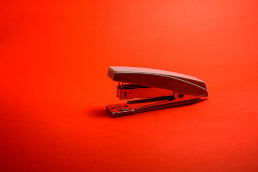 Stapler Isolated on Red Background, Side View