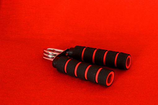 a pair of hand sport training device isolated on red background.