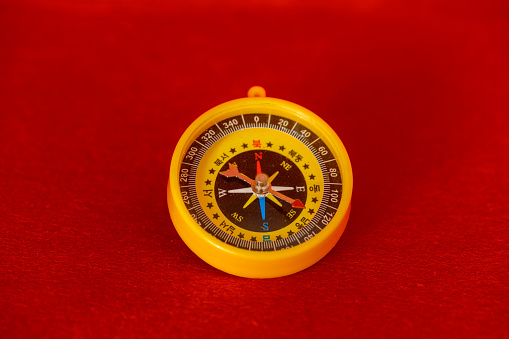 A compass on red with soft shadow