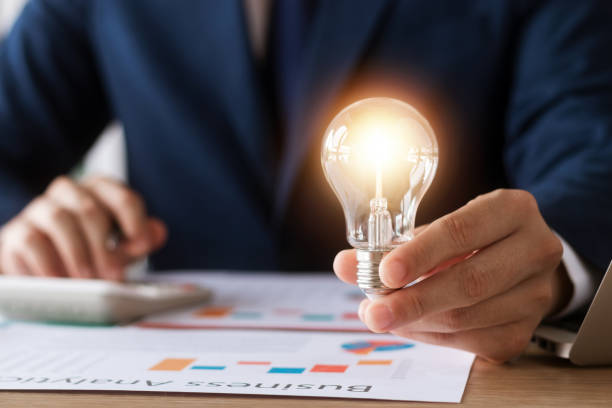 Innovation through ideas and inspiration ideas. Human hand holding light bulb to illuminate, idea of creativity and inspiration concept of sustainable business development. stock photo