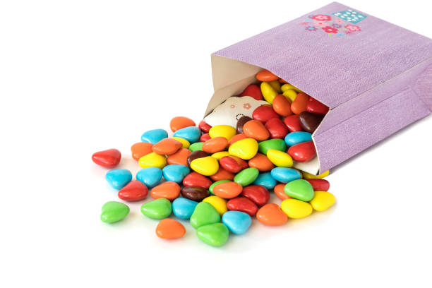 Small multi-colored dragee candies with chocolate filling on a white background in bulk.