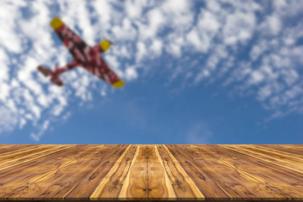 istock Wooden table with blur sky and plane background 1438552654