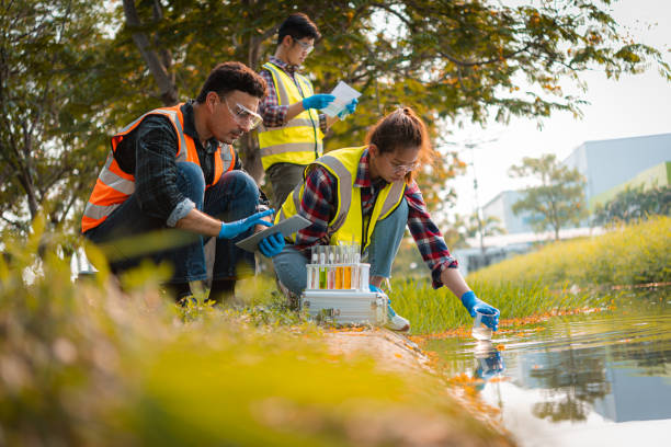 l’équipe de scientifiques recueille des échantillons d’eau pour l’analyse et la recherche sur la qualité de l’eau, l’environnement avec la sauvegarde de la terre. - scientist research group of people analyzing photos et images de collection