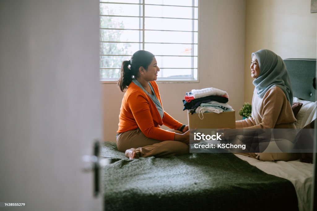 Mother and daughter preparing clothes for donating Women, Packing, Love, Donate, Indian, Malay Charitable Donation Stock Photo