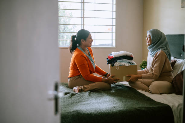 Mother and daughter preparing clothes for donating stock photo