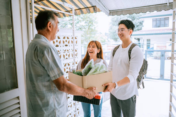 Asian Chinese volunteer visit old man house for helping stock photo