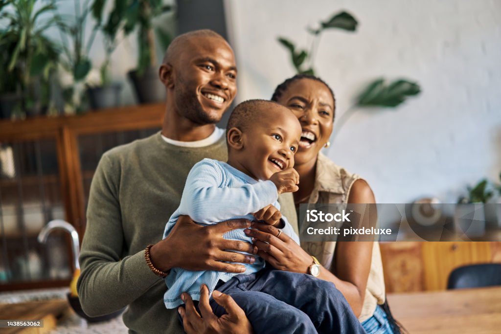 Love, child and happy black family of mother, father and young kid bond and enjoy fun quality time together. Happiness, smile and excited happy family of baby, dad and mom or mama laugh in kitchen Family Stock Photo
