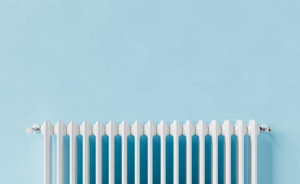 White radiator on blue wall stock photo