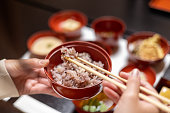 Female tourist eating 'sekihan' red bean rice using chopsticks