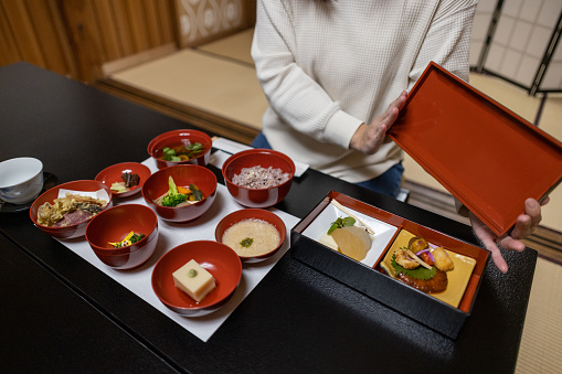 Female tourist opening a box of main dish - shojin ryori