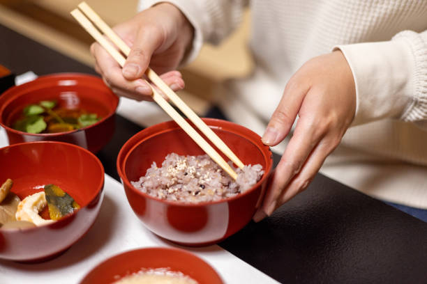istock Female tourist eating 'sekihan' red bean rice using chopsticks 1438565598