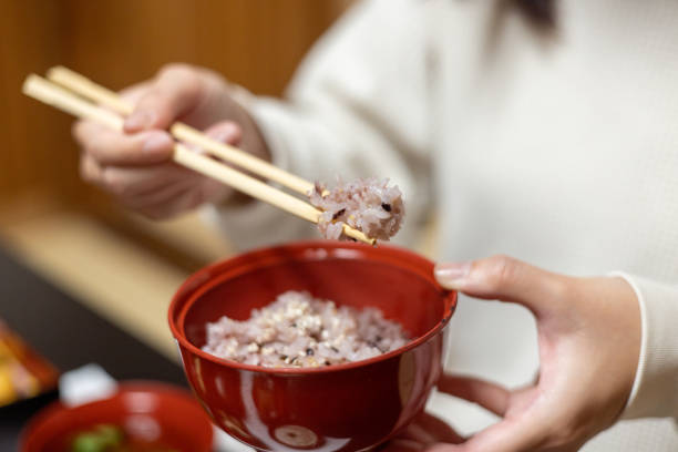 Female tourist eating 'sekihan' red bean rice using chopsticks