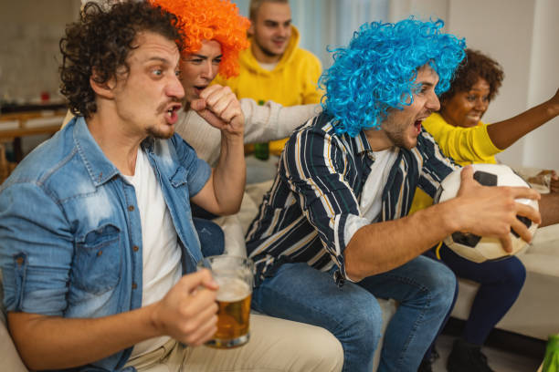 istock Friends celebrate soccer team win at home 1438567143