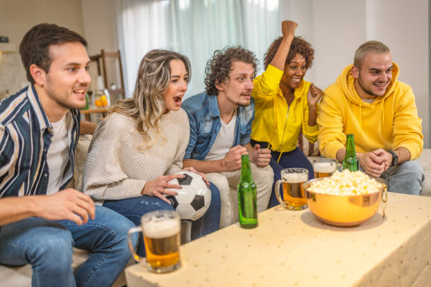 istock Soccer fans emotionally watching game at home. 1438567190