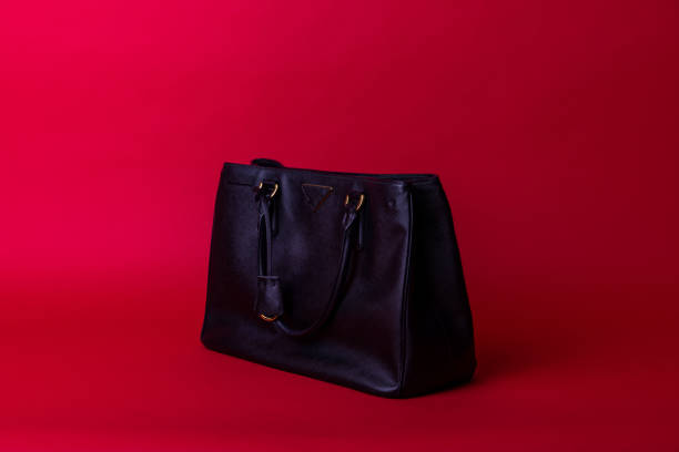 istock Expensive leather hand bag in red background. 1438569333