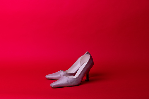 Luxury woman shoe in red background.