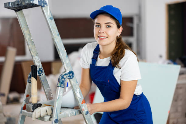istock Positive young female builder contractor inspecting room and taking notes 1438570769