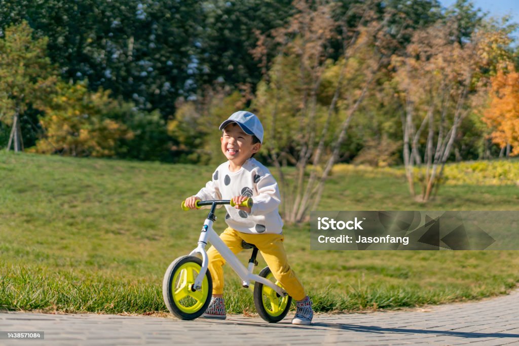 Baby Baby practicing cycling in the park Tricycle Stock Photo