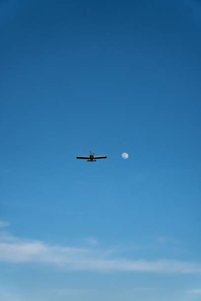 istock Red airplane flying through the blue sky with a white contrail trace above it during daytime 1438572858